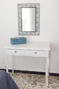escritorio blanco con espejo en la pared en Apartamento CaMaría Castillo 3º, en Peñíscola