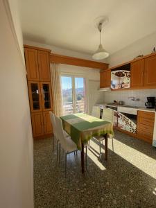 a kitchen with a table and some chairs and a window at Mpanos Sea Apartment 2 in Loutra Oraias Elenis