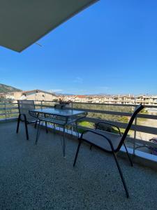 a patio with a table and chairs on a balcony at Mpanos Sea Apartment 2 in Loutra Oraias Elenis