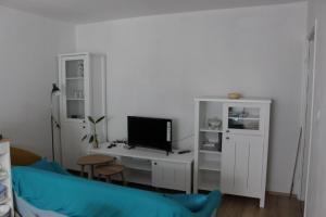 a living room with a tv and a desk with a computer at Blue Harbour No. 15 in Veli Iž