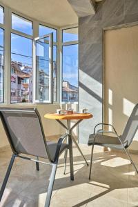 a table and two chairs in a room with windows at Kings View in Veliko Tŭrnovo
