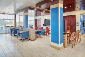 a dining area with tables and chairs in a building at Holiday Inn Express & Suites El Paso East-Loop 375 by IHG in El Paso
