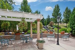 eine Terrasse mit einer Pergola sowie Tischen und Stühlen in der Unterkunft Holiday Inn Express Hotel & Suites Youngstown North-Warren/Niles, an IHG Hotel in Warren