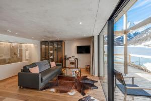 a living room filled with furniture and a window at Matterhorn FOCUS Design Hotel in Zermatt