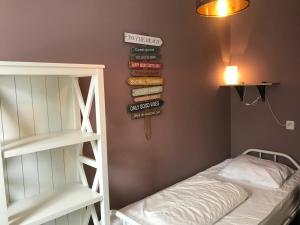 um quarto com uma cama e uma pilha de livros em Zeebries in De Kaap 4 p em Hollum