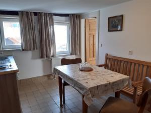 a dining room with a table and chairs and windows at Pension Will in Kusterdingen