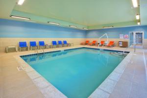una grande piscina in una stanza d'ospedale con sedie di Holiday Inn Express & Suites New Castle, an IHG Hotel a New Castle