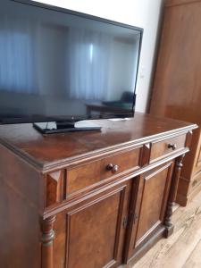 a television on top of a wooden dresser at Pension Will in Kusterdingen