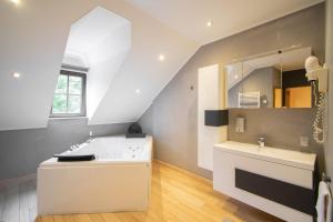 ein Bad mit einem Waschbecken und einem Spiegel in der Unterkunft Aux Tanneries de Wiltz in Wiltz