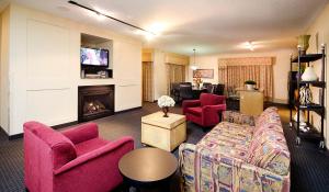 Lake ElmoHoliday Inn St. Paul Northeast - Lake Elmo by IHG的客厅配有粉色家具和壁炉