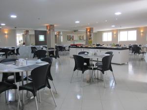 a dining room with tables and chairs in a restaurant at Hotel Maysa Caruaru in Caruaru