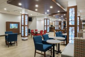 a waiting room with blue chairs and tables and tablesktop at Holiday Inn Express & Suites West Plains Southwest by IHG in West Plains