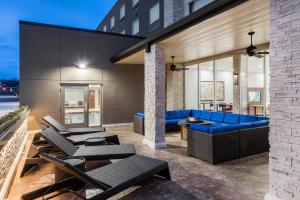 a patio with a blue couch and tables at Holiday Inn Express & Suites West Plains Southwest by IHG in West Plains