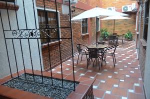 eine Terrasse mit Tischen, Stühlen und einem Sonnenschirm in der Unterkunft Hotel Balcon Llanero in Cúcuta