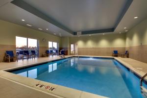 een groot zwembad met blauw water in een gebouw bij Holiday Inn Express & Suites Findlay North, an IHG Hotel in Findlay
