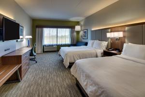 a hotel room with two beds and a flat screen tv at Holiday Inn Express & Suites Findlay North by IHG in Findlay
