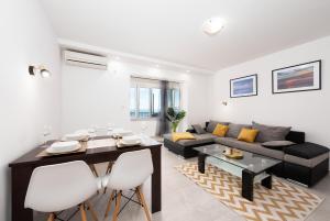 - un salon avec une table et un canapé dans l'établissement Apartment Stella, à Opatija