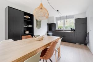 een keuken met een grote houten tafel en stoelen bij vakantiehuis Seaside, Dunoweg 18 in Oostkapelle