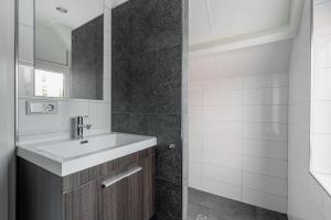 een badkamer met een wastafel en een spiegel bij vakantiehuis Seaside, Dunoweg 18 in Oostkapelle