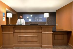 a man standing at a reception desk in a hotel room at Holiday Inn Express Hotel & Suites Fraser Winter Park Area by IHG in Fraser +50 photos