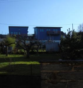 a blue house in a yard with a fence at Penthouse Mosel Hunter in Gornhausen