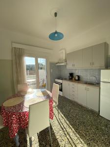 a kitchen with a table and chairs and a kitchen with a window at Mpanos Sea Apartment 1 in Loutra Oraias Elenis