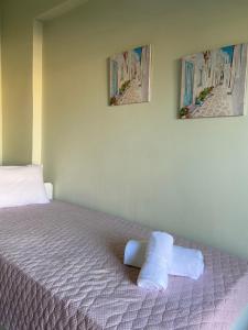 a bedroom with a bed with two pictures on the wall at Mpanos Sea Apartment 1 in Loutra Oraias Elenis