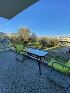 a table and two chairs sitting on a balcony at Mpanos Sea Apartment 1 in Loutra Oraias Elenis