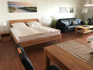 a living room with a bed and a couch at Steiner Strandappartements Appartement 302 Seeseite in Stein