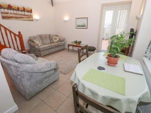 a living room with a table and a couch at The Old Coach House in Penmaen-mawr