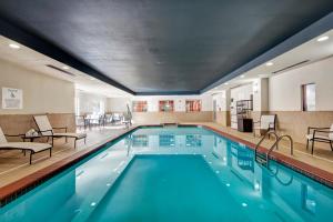 a pool in a hotel with chairs and tables at Holiday Inn Express and Suites Oklahoma City North by IHG in Oklahoma City
