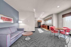 a living room with a couch and a table and chairs at Holiday Inn Express and Suites Oklahoma City North by IHG in Oklahoma City