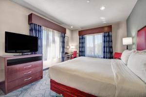 a hotel room with a bed and a flat screen tv at Holiday Inn Express and Suites Oklahoma City North by IHG in Oklahoma City