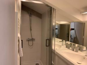 a bathroom with two sinks and a shower and a mirror at Residence Service Appart Hôtel in Clamart