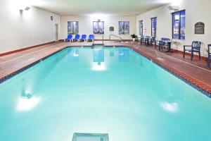 ein großer Pool mit blauen Stühlen in einem Gebäude in der Unterkunft Holiday Inn Express & Suites Midwest City, an IHG Hotel in Midwest City