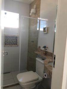 a white bathroom with a toilet and a shower at Casa na Praia do Piruí - Arembepe in Arembepe