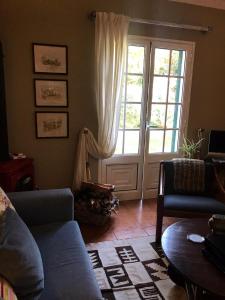 a living room with a couch and a large window at Palheirinho da Camélia in São Vicente