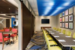 comedor con mesas y sillas y techos azules en Holiday Inn Express & Suites - Nebraska City, an IHG Hotel, en Nebraska City