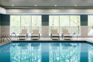 una piscina en un hotel con sillas y ventanas en Holiday Inn Express & Suites - Nebraska City, an IHG Hotel, en Nebraska City