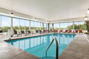 una piscina con sillas, mesas y ventanas en Holiday Inn Express & Suites Florence, an IHG Hotel en Florence