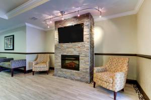 a waiting room with a fireplace and a flat screen tv at Holiday Inn Express Hotel & Suites Live Oak, an IHG Hotel in Live Oak