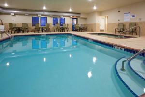a large swimming pool with chairs and tables at Holiday Inn Express & Suites Willmar, an IHG Hotel in Willmar
