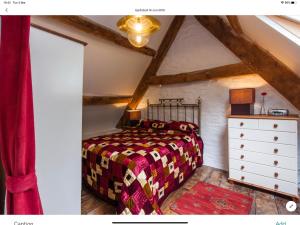 a bedroom with a bed and a dresser in a attic at Ty Fferm Hen, The Ancient Farmhouse in Talybont