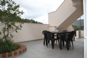 a black dining table and chairs on a patio at Appartamenti Amaretto e Pardula in Fluminimaggiore