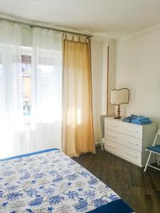 a bedroom with a bed and a dresser and a window at Appartamento Azzurro Mare in Sestri Levante