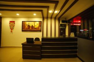 a restaurant with a counter and stairs in a room at Kairali Tourist Home in Guruvāyūr