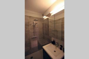 a bathroom with a sink and a shower at Knappe studio met subliem zeezicht! in Ostend +31 photos