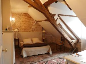 a bedroom with a bed in a attic at La Maison XVIIIe in Moulins