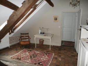 um quarto no sótão com uma mesa e uma cadeira em La Maison XVIIIe em Moulins