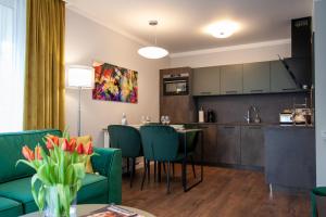 een keuken en een woonkamer met groene stoelen en een tafel bij Apartament Leśny No 5 Green ,garaż w cenie in Kielce